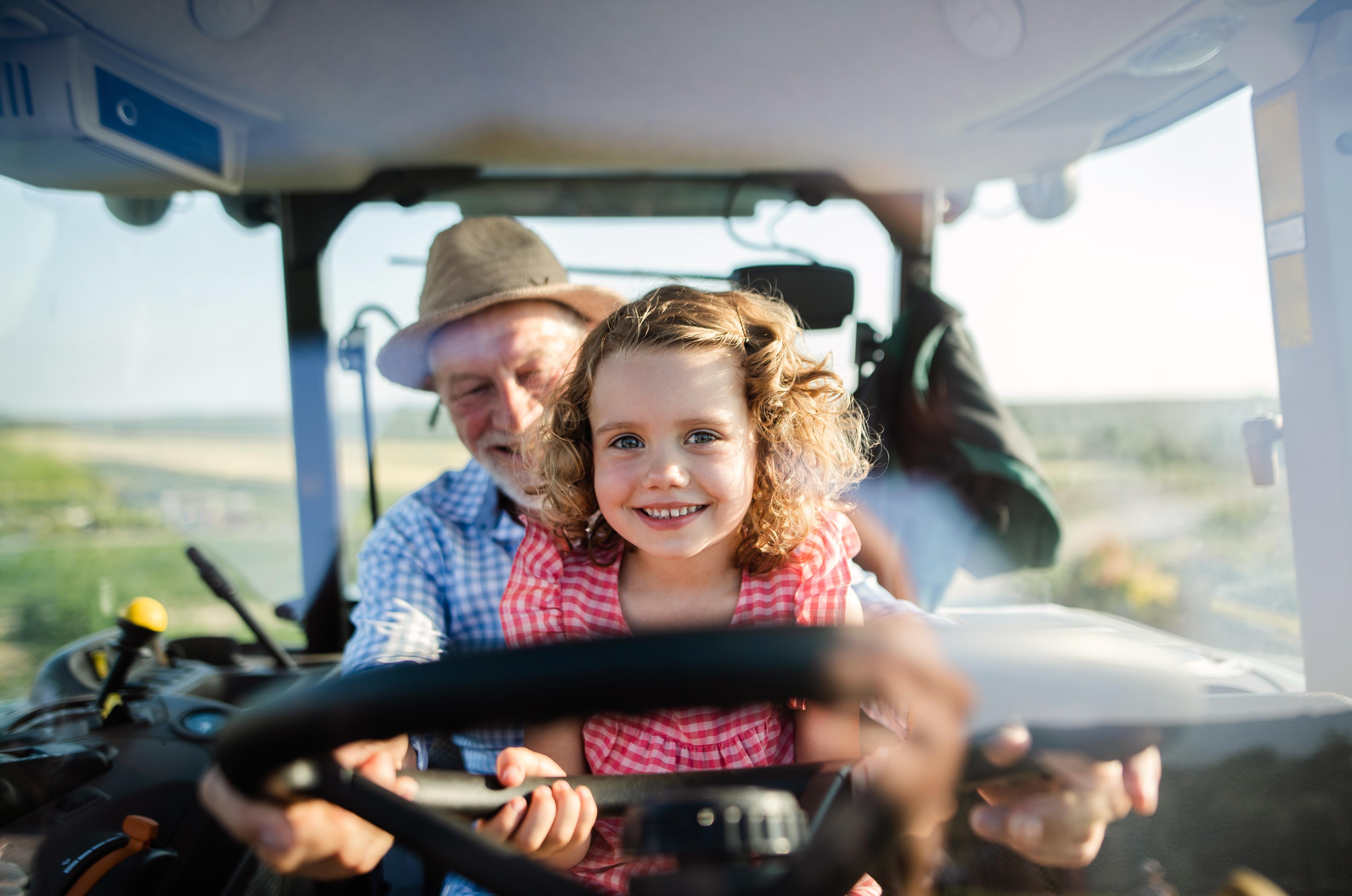 Image of Senior and Child on Tractor Smiling