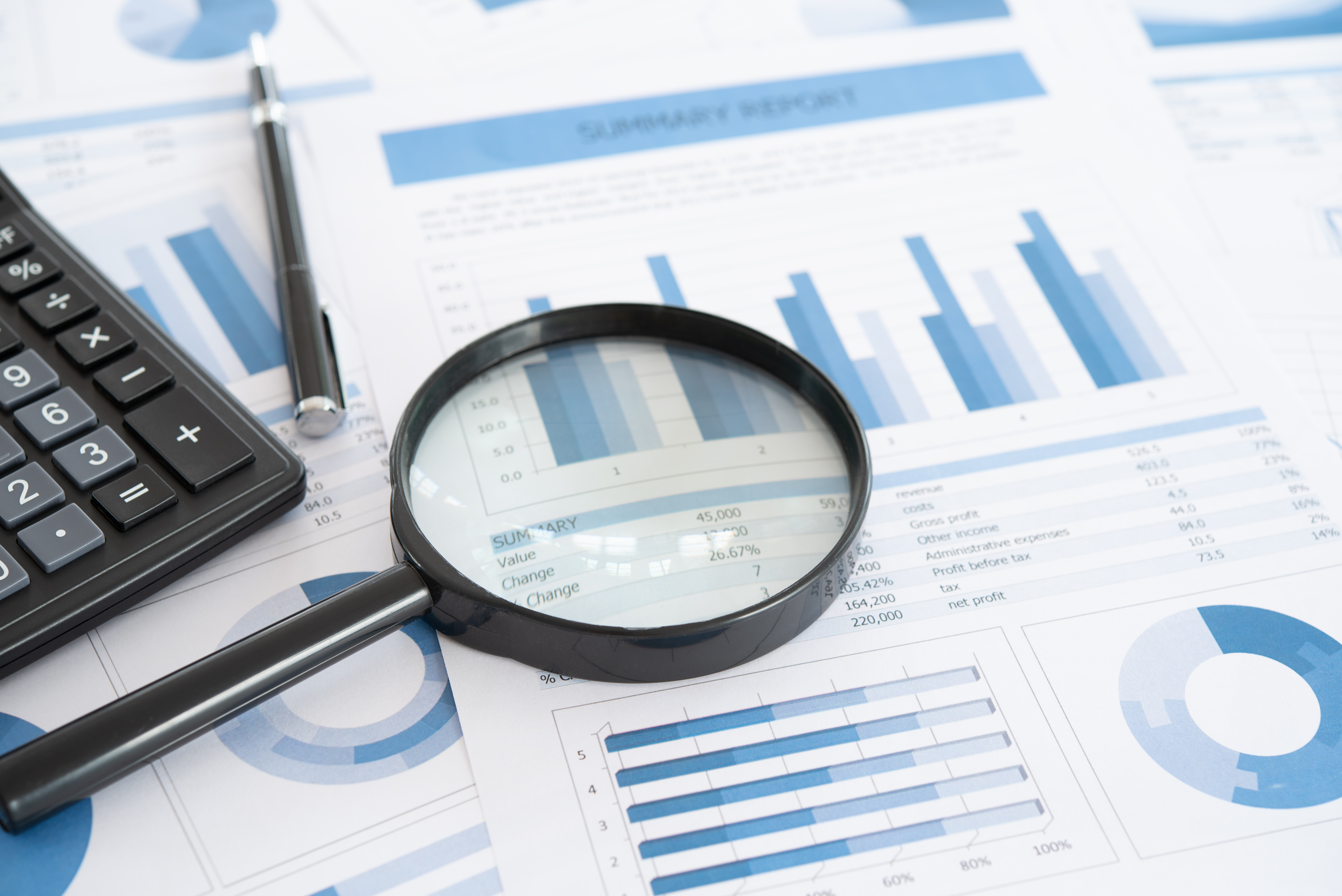 Image of Magnifying Glass and Calculator on Financial Statements