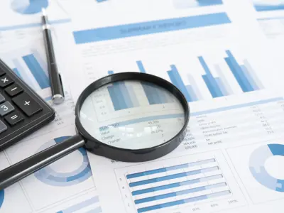 Image of Magnifying Glass and Calculator on Financial Statements