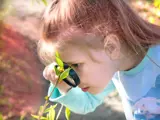 Image of Girl with Magnifying Glass and Plants